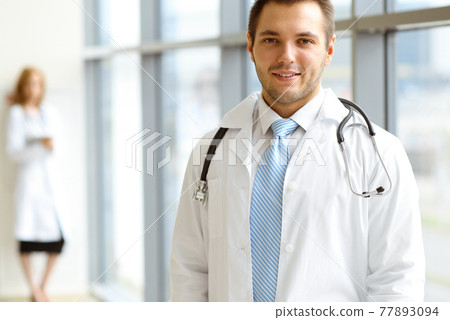 Male dark hair doctor standing in the modern clinic. Perfect medical service in the hospital. Medicine concept 77893094