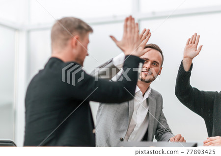 confident business colleagues giving each other a high five confident business colleagues giving each other a high five 77893425