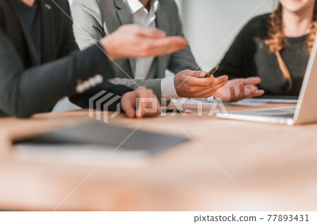 close up. working group discussing something at a group meeting close up. working group discussing something at a group meeting 77893431