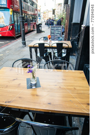 The streets of Shaw Didge in the east of London: Black chairs and tables with iron pipes placed in front of the store. 77894848