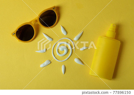 Summer concept with sunscreen on yellow background Summer concept with sunscreen on yellow background 77896150