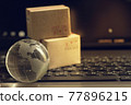 Shopping online, e-commerce concept: Crystal globe with cardboard boxes on keyboard. depicts of purchase of products on internet used for worldwide international connections. 77896215