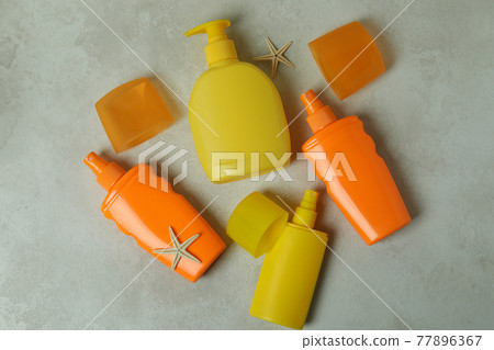 Summer concept with sunscreens on textured background Summer concept with sunscreens on textured background 77896367