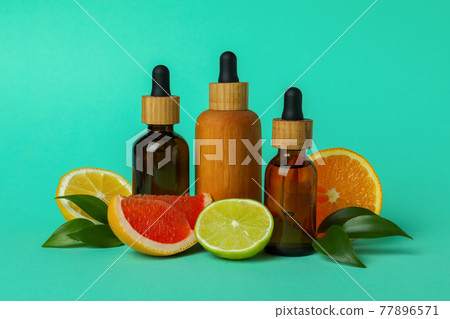 Dropper bottles with oil and citrus on mint background Dropper bottles with oil and citrus on mint background 77896571