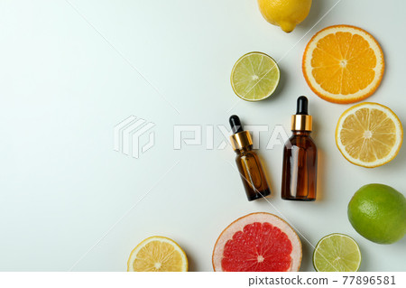 Dropper bottles with oil and citrus on white background Dropper bottles with oil and citrus on white background 77896581