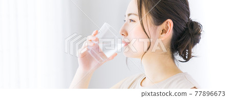 一個年輕的女人喝礦泉水 77896673