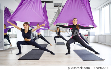 Fly yoga, female group training with hammocks 77896885