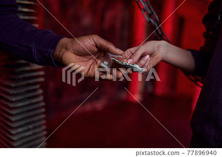Drug addict woman buys a dose from a dealer Drug addict woman buys a dose from a dealer 77896940