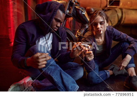 Drug addict man and woman smokes a cigarette Drug addict man and woman smokes a cigarette 77896951