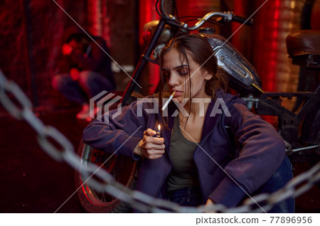 Drug addict woman smokes cigarette while she high 77896956