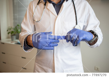 doctor taking off blue gloves doctor taking off blue gloves 77897270