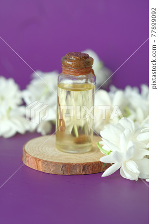 eucalyptus essential oils in a glass bottle and flower on purple background eucalyptus essential oils in a glass bottle and flower on purple background 77899092