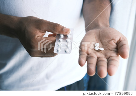 Close up of hand holding blister packs . 77899093