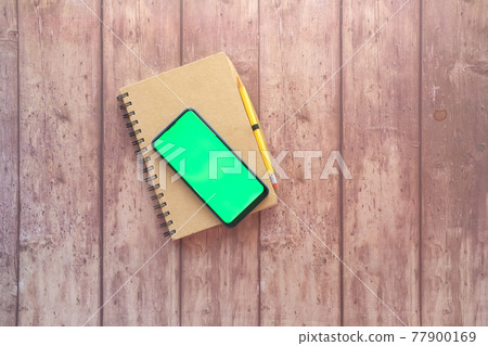 top view of smart phone and notepad on table top view of smart phone and notepad on table 77900169