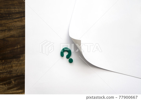 The left edge of the paper is turned over and a question mark appears 77900667