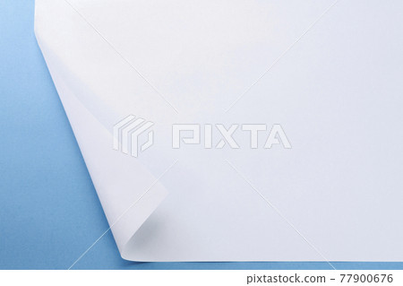 The left edge of the paper is turned over and you can see the blue background The left edge of the paper is turned over and you can see the blue background 77900676