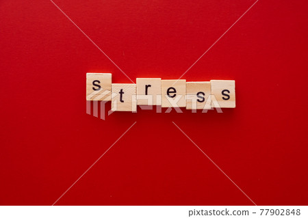 word STRESS made of wooden letters on red background with copy space 77902848