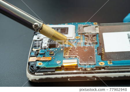 Technician repairing inside of mobile phone by soldering iron. Integrated Circuit. the concept of data, hardware, technology. Technician repairing inside of mobile phone by soldering iron. Integrated Circuit. the concept of data, hardware, technology. 77902948
