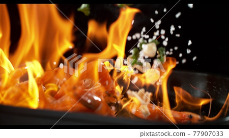 Super slowmotion footage of throwing fresh prawns and seasoning on ignited pan, 1000fps 4k 77907033