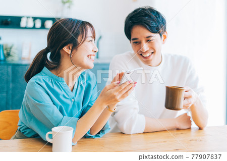 Young couple looking at smartphone together 77907837