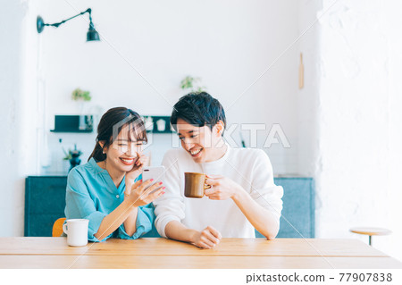 Young couple looking at smartphone together Young couple looking at smartphone together 77907838