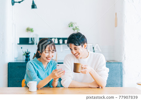 Young couple looking at smartphone together 77907839