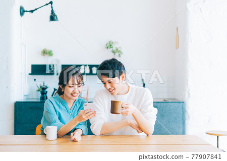 一起看智能手機的年輕夫婦 77907841