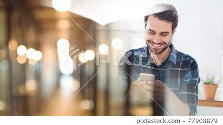 Composition of smiling man using smartphone in office with blurred overlay Composition of smiling man using smartphone in office with blurred overlay 77908879