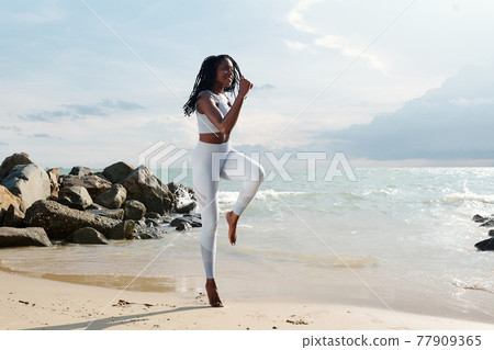 Woman doing jumping exercise 77909365