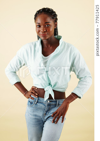 Smiling young woman in jeans and shirt Smiling young woman in jeans and shirt 77911425