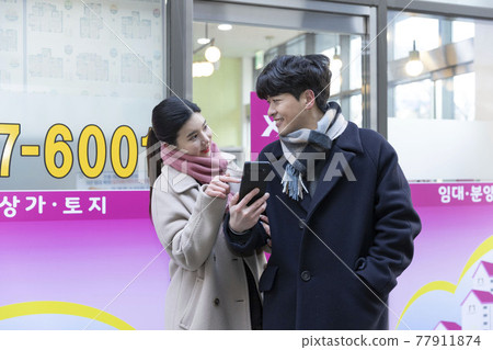 newly married Asian couple infront of real estate brokerage office, searching house newly married Asian couple infront of real estate brokerage office, searching house 77911874