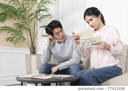 Asian newlyweds, couple managing home living expense Asian newlyweds, couple managing home living expense 77911886
