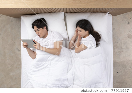 Asian wife mad at husband concentrated on tablet pc Asian wife mad at husband concentrated on tablet pc 77911937