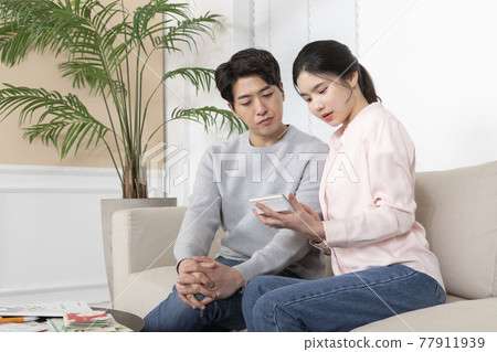 Asian newlyweds, couple managing home living expense concept, holding calculator Asian newlyweds, couple managing home living expense concept, holding calculator 77911939