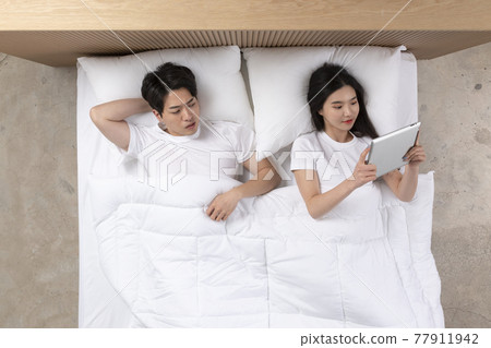 Asian husband mad at wife concentrated on tablet pc 77911942
