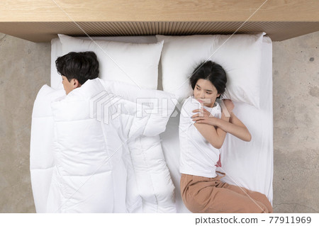 Asian couple fighting over blanket Asian couple fighting over blanket 77911969