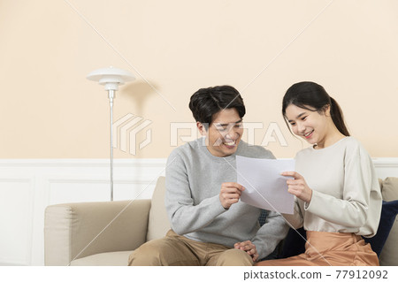 newly married Asian couple holding paper, house contract, test result newly married Asian couple holding paper, house contract, test result 77912092