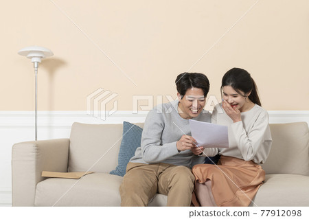 newly married Asian couple holding paper, house contract, test result newly married Asian couple holding paper, house contract, test result 77912098