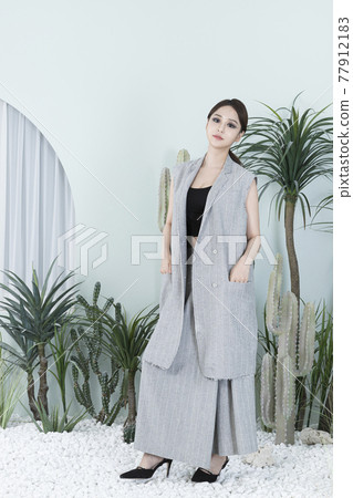Asian female model in suit with dark smokey makeup, cactus background Asian female model in suit with dark smokey makeup, cactus background 77912183