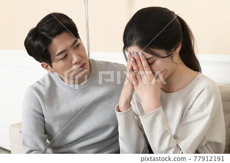 Asian husband comforting, calming down Asian wife 77912191