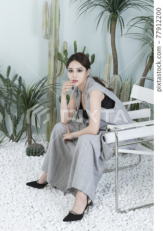 Asian female model in suit with dark smokey makeup, cactus background Asian female model in suit with dark smokey makeup, cactus background 77912200