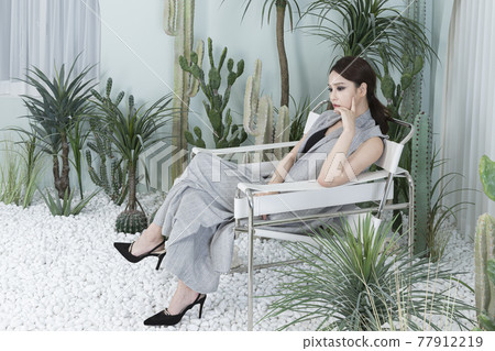 Asian female model in suit with dark smokey makeup, cactus background 77912219