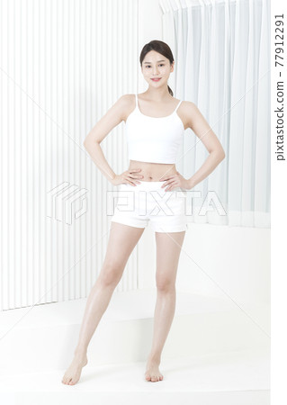 Beautiful Asian model in white slip and shorts, body and skin beauty concept Beautiful Asian model in white slip and shorts, body and skin beauty concept 77912291