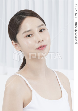 closeup of beautiful Asian model smiling face with glowing skin closeup of beautiful Asian model smiling face with glowing skin 77912387