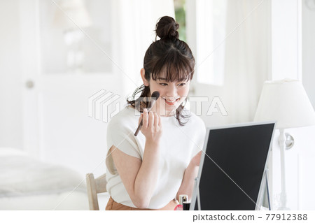 Woman doing make-up Woman doing make-up 77912388