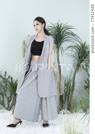 Asian female model in suit with dark smokey makeup, cactus background Asian female model in suit with dark smokey makeup, cactus background 77912488