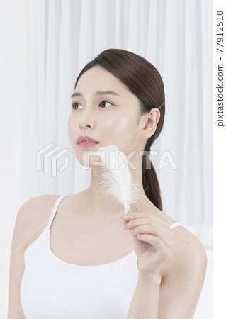 beautiful Asian model with feather, moisturizing skin care concept beautiful Asian model with feather, moisturizing skin care concept 77912510