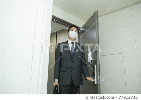 Asian business man in suit wearing mask before going out Asian business man in suit wearing mask before going out 77912730