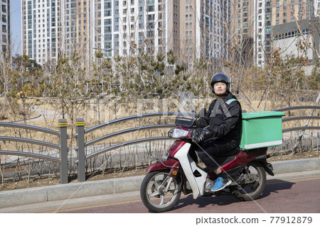 food delivery male courier riding motorcycle, scooter to deliver orders food delivery male courier riding motorcycle, scooter to deliver orders 77912879