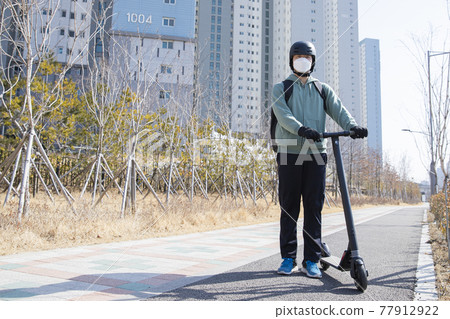 food delivery male courier riding electric scooter to deliver orders food delivery male courier riding electric scooter to deliver orders 77912922